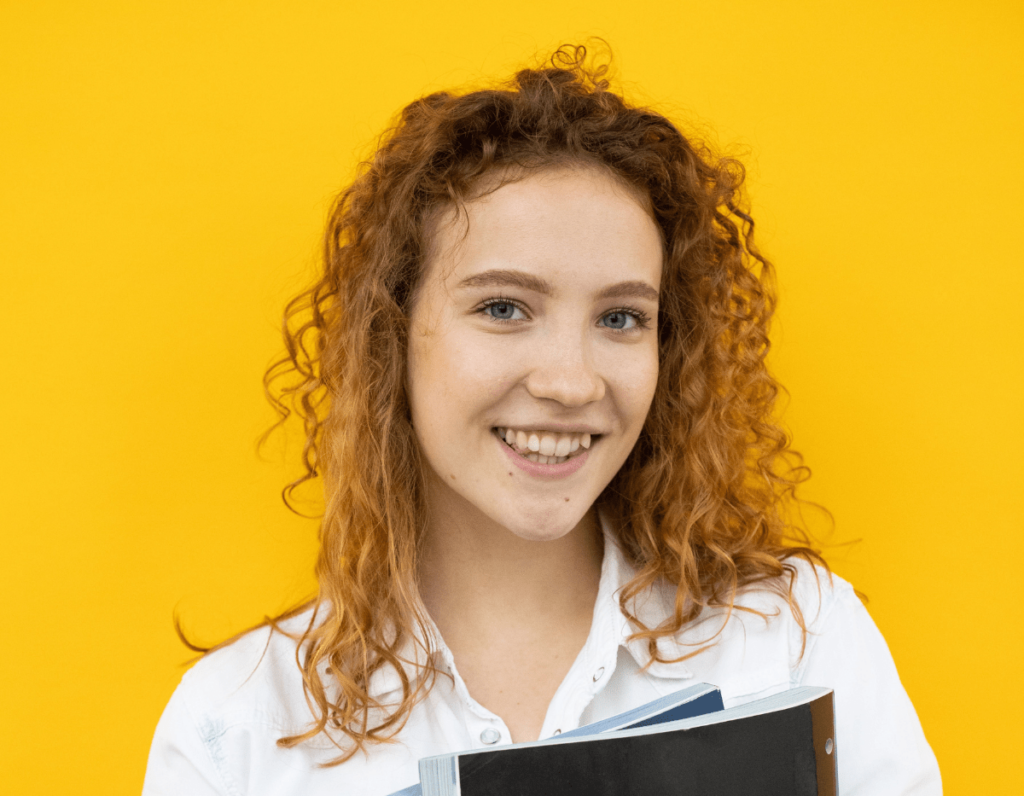 young woman smiling on gold background